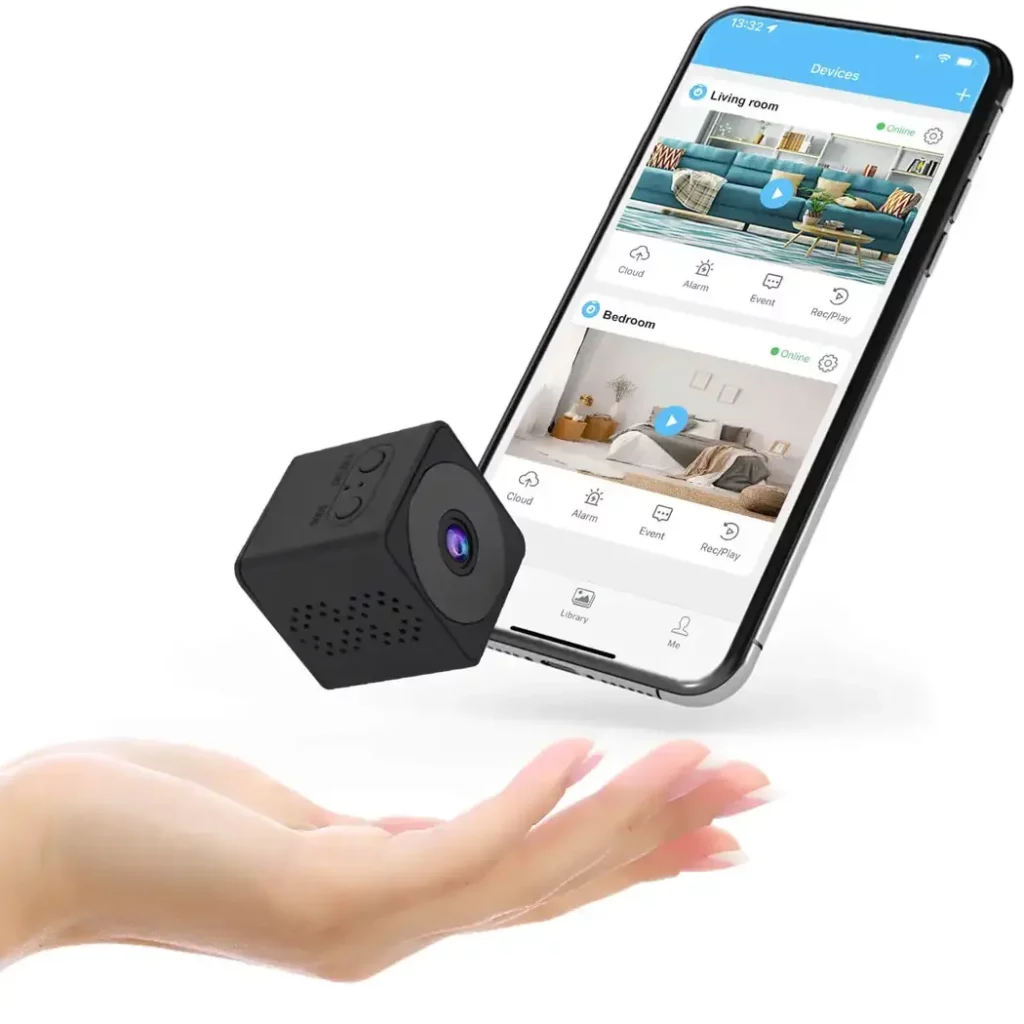 The Dealeez mini spy camera and a phone connected to the HIDVCAM application floating above a hand
