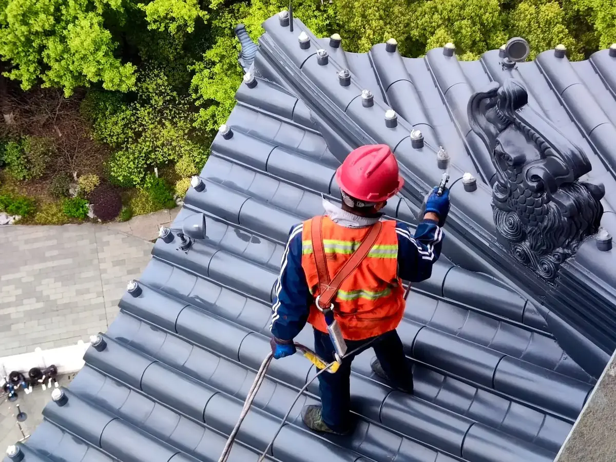 Arbeiter auf einem Dach, der mit seiner Baulampe arbeitet