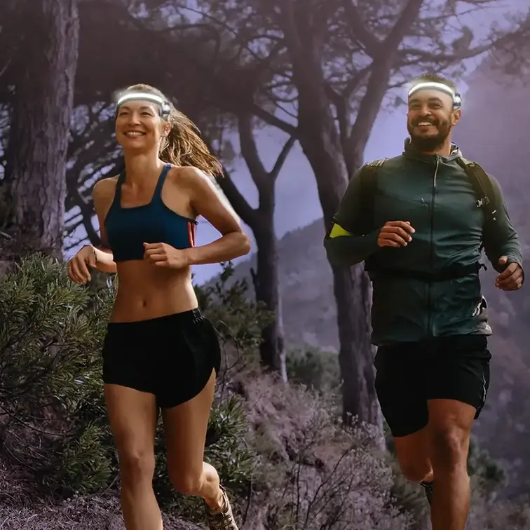 Two joggers running with headlamps